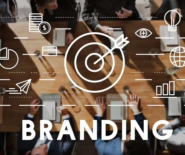 A blurred picture of the top view of a business meeting on a wooden table, with white vector graphics on it and the title "Branding"